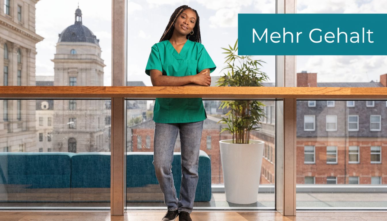 Eine junge Pflegerin mit grüner Arbeitskleidung steht selbstbewusst vor einem Bürofenster mit städtischem Ausblick.