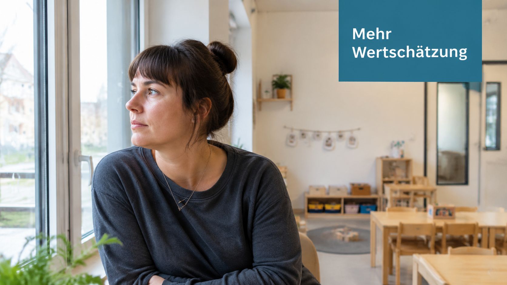 Eine nachdenkliche Erzieherin schaut in einem hellen, freundlich gestalteten Kindergarten aus dem Fenster.
