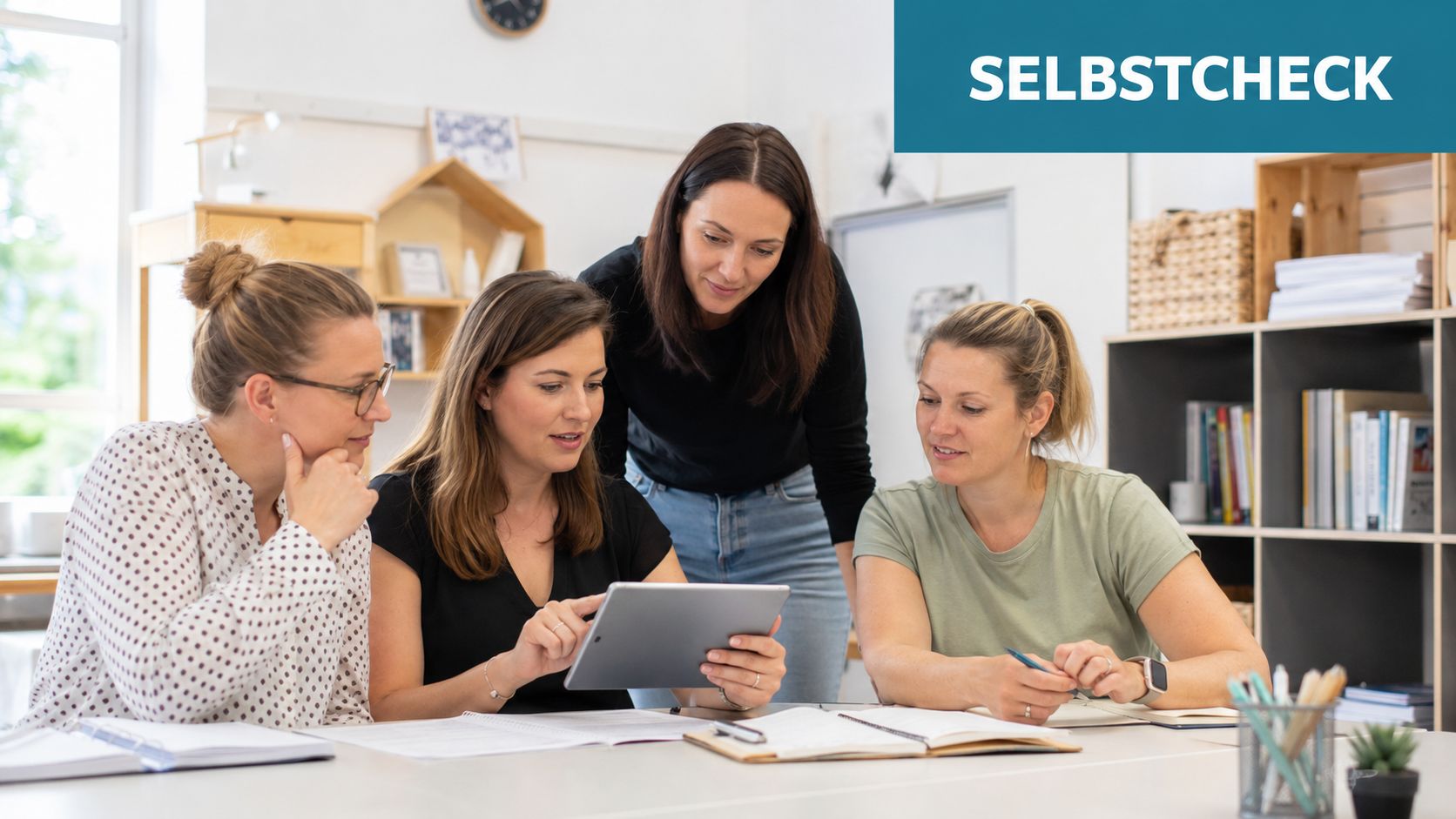 Vier Frauen sitzen gemeinsam an einem Tisch und arbeiten fokussiert an einem Tablet für eine Fortbildung.
