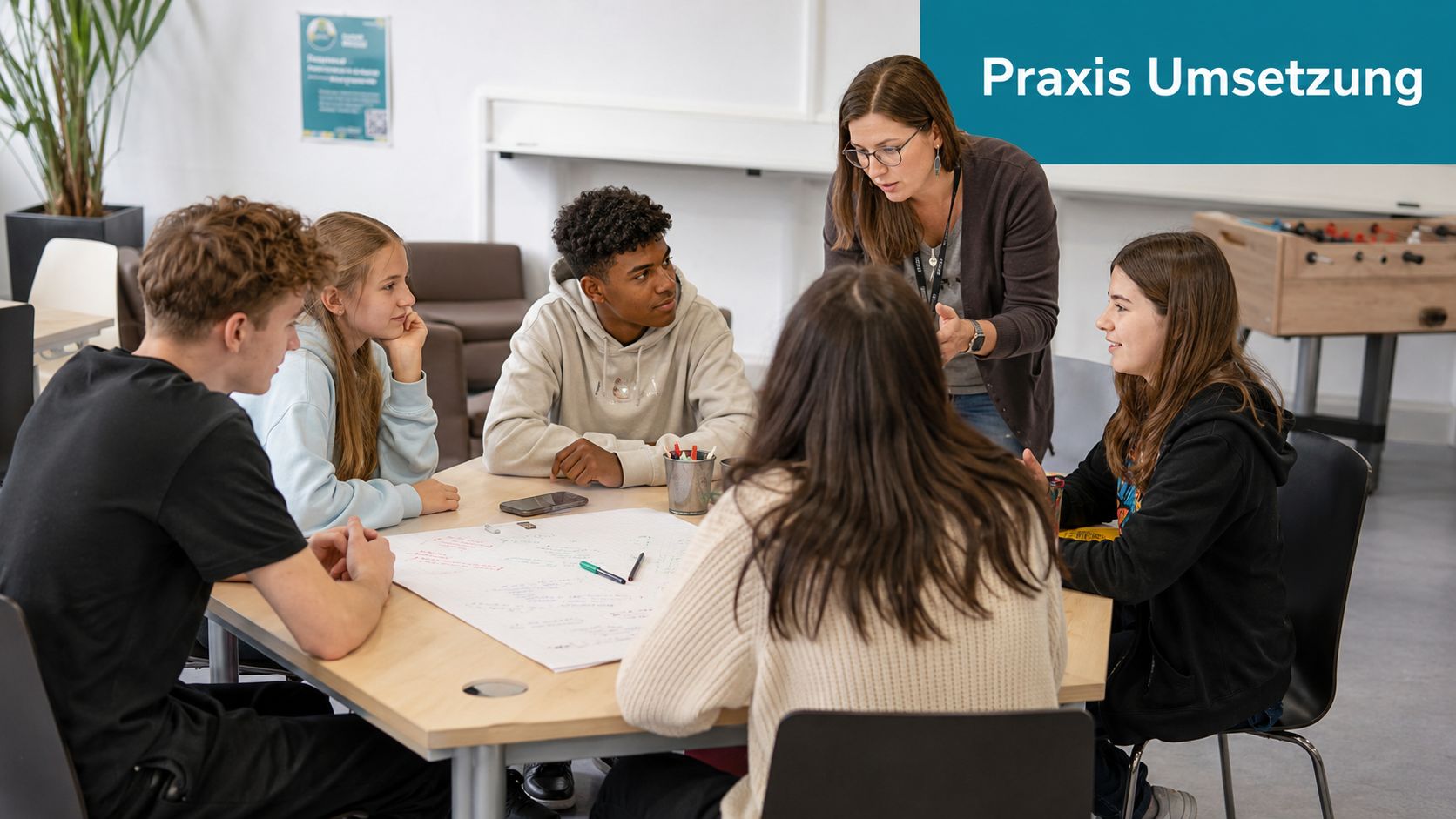 Eine Lehrerin bespricht ein Projekt mit einer Gruppe von Schülern in einem modernen Unterrichtsraum.
