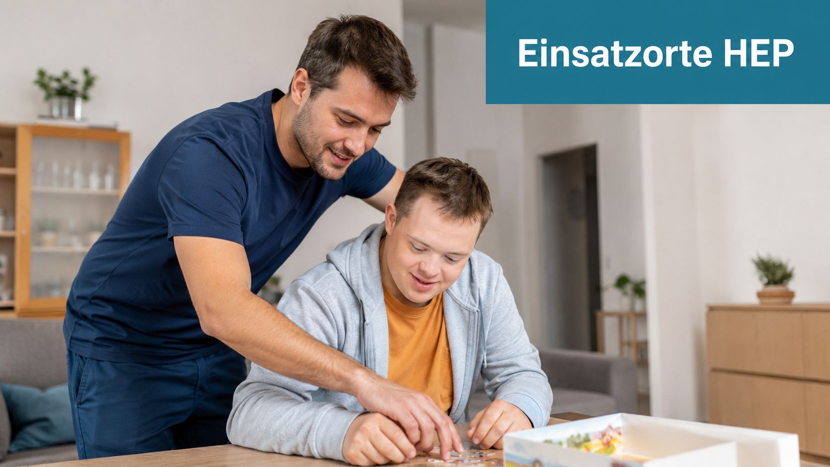 Ein Heilerziehungspfleger unterstützt einen jungen Mann mit Down-Syndrom geduldig beim gemeinsamen Puzzeln im häuslichen Wohnumfeld.