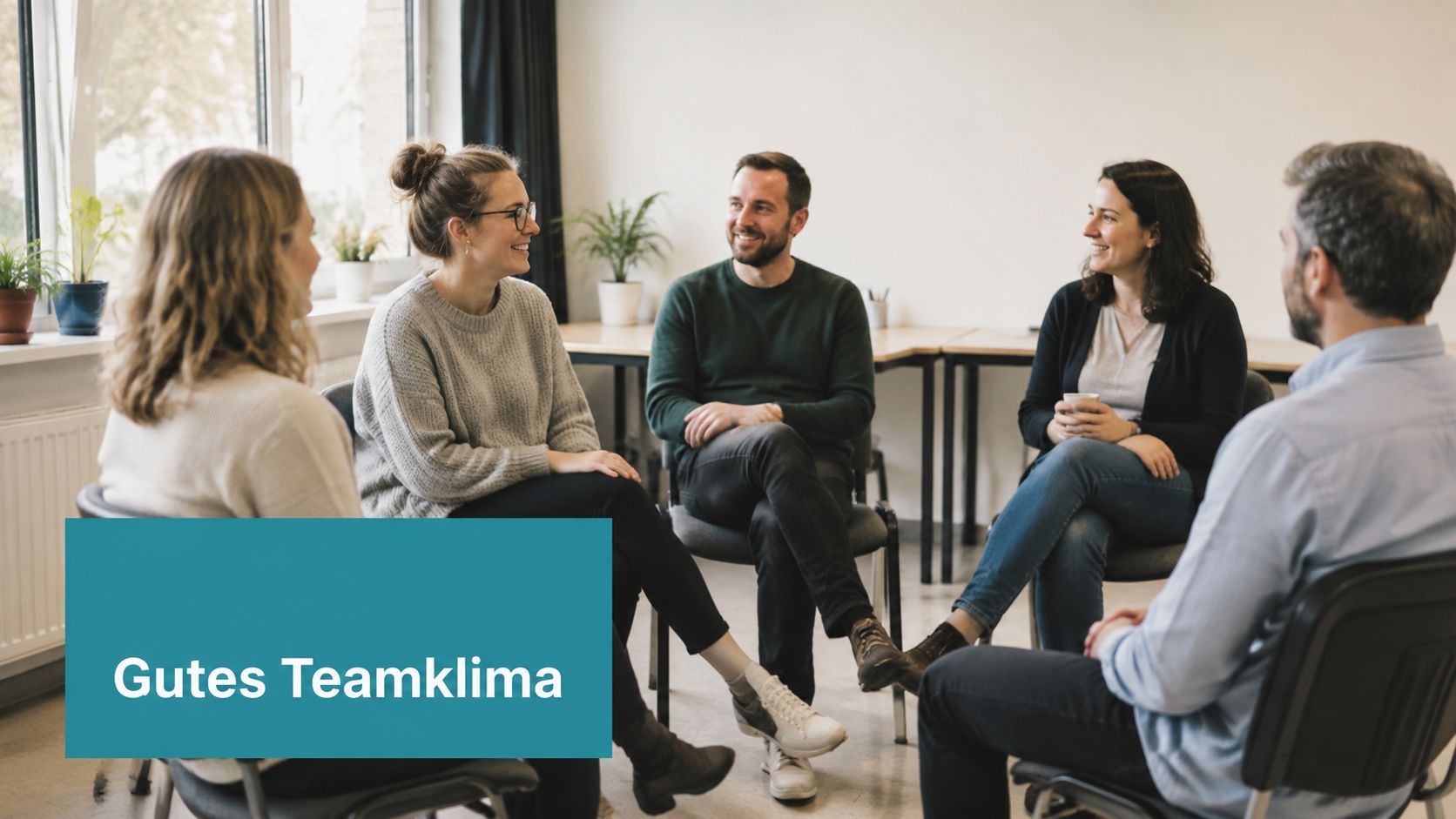 Ein diverses Team sitzt in einem hellen Büro im Kreis zusammen und führt ein positives Gespräch.
