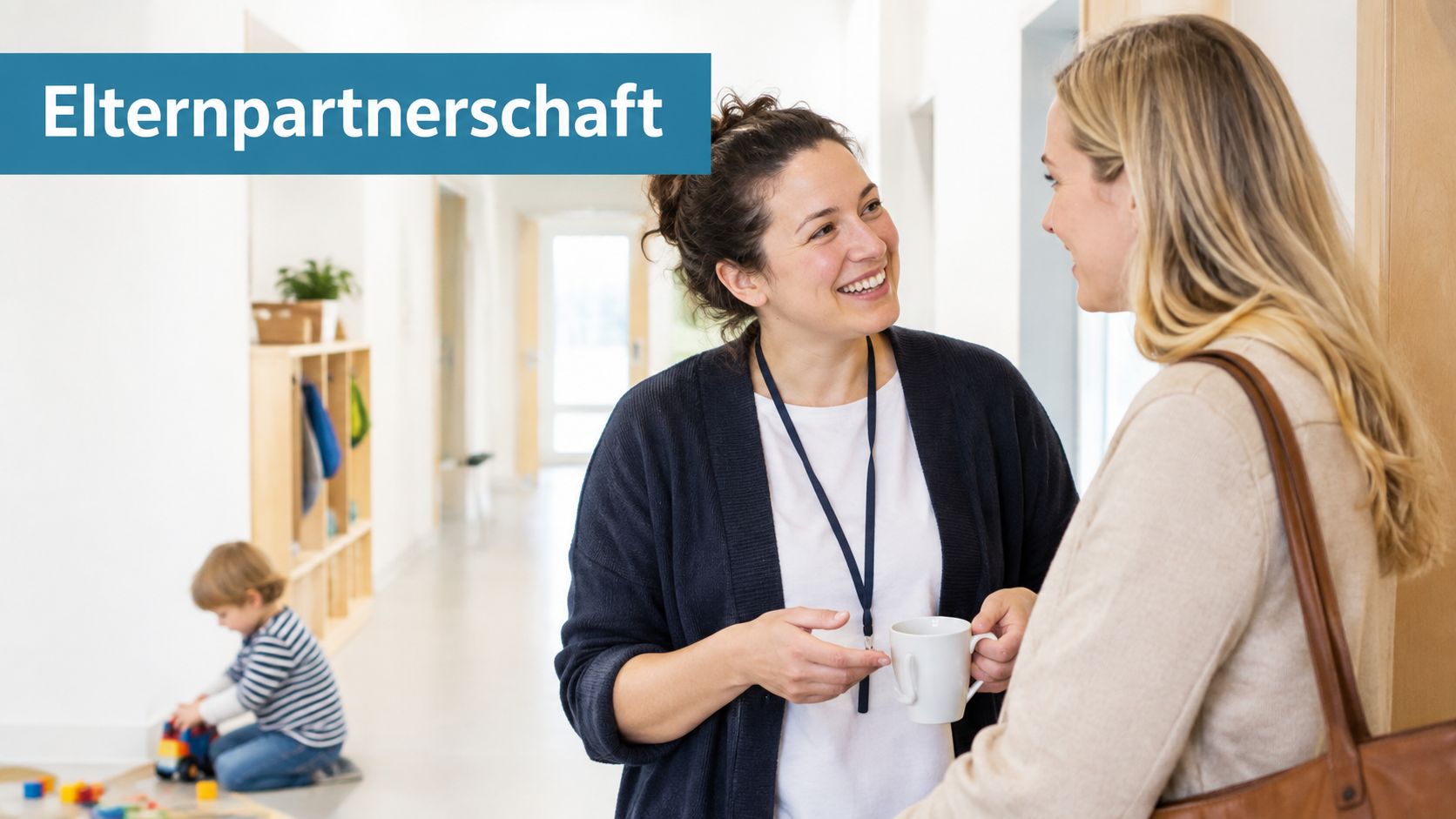 Eine Erzieherin unterhält sich freundlich mit einer Mutter in einem hellen Kindergartenflur während ein Kind spielt.